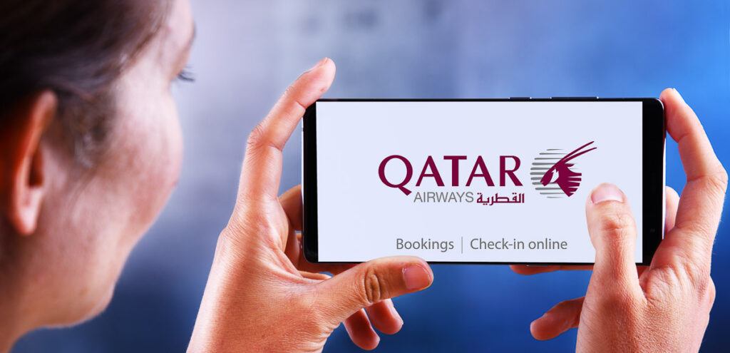Una mujer sostiene un teléfono móvil con una página del sitio web de Qatar en la pantalla y está lista para usar el servicio QVerse.